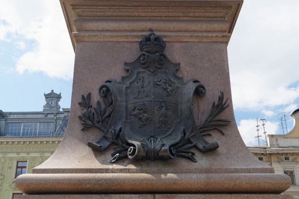 Z tyłu pomnika znajduje się herb Rzeczypospolitej Obojga Narodów - Na przemian dwa pola przedstawiają orła i pogoń