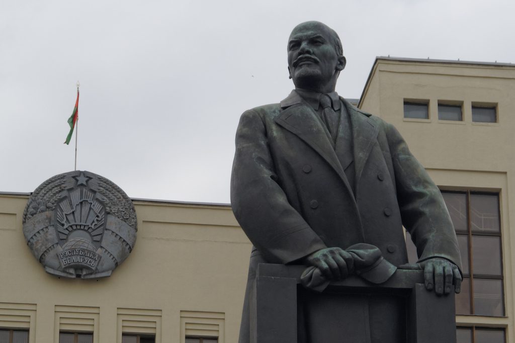 Lenin przed budynkiem parlamentu Republiki Białorusi, po lewej flaga i godło Białorusi (wzorowane na godle ZSRR)